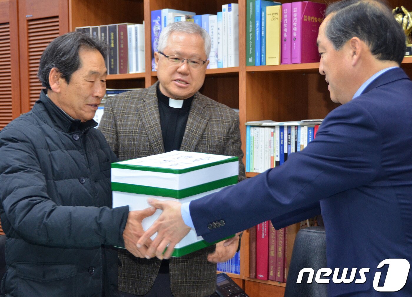 본문 이미지 - 이병선 속초시장(오른쪽)이 8일 시청 집무실에서 김경식 고층건물반대대책위원장으로부터 동명동성당 앞 고층건물을 반대하는 천주교 신자와 시민 2만여명이 작성한 서명부를 전달받고 있다. 2018.3.8/뉴스1 ⓒ News1 고재교 기자