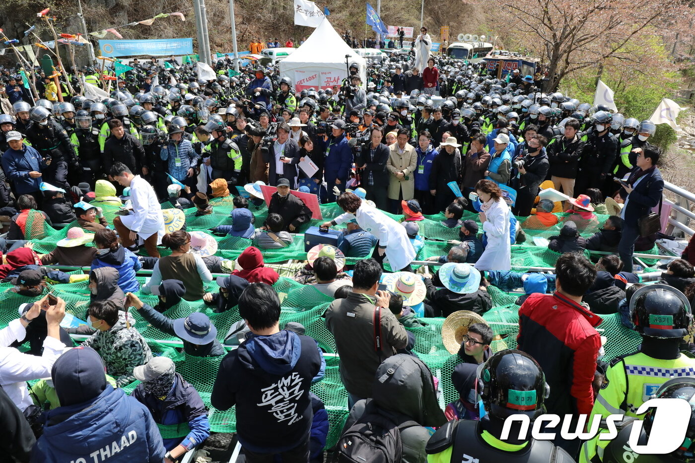 본문 이미지 - 주한미군 성주 사드(THAAD·고고도미사일 방어체계) 기지 내 환경개선 공사를 위한 장비 투입이 시작했다. 12일 오전 사드 반대 단체와 주민들이 철제프레임과 그물망으로 엮어 집회 도중 부상자가 발생해 의료진이 투입되고 있다. 2018.4.12/뉴스1 ⓒ News1 공정식 기자