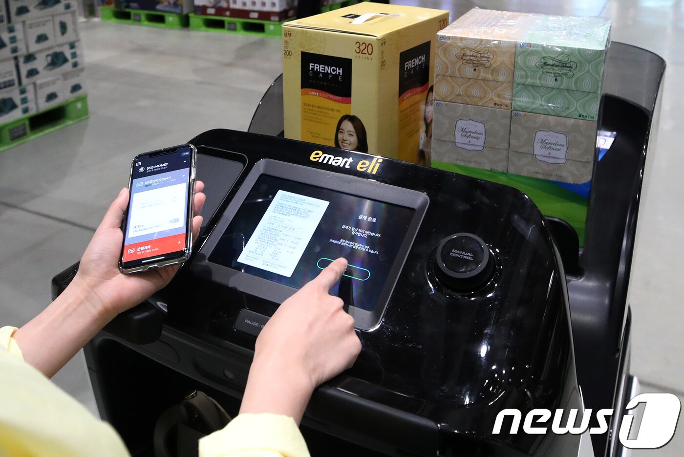 본문 이미지 - 17일 경기도 하남시 스타필드 하남점 이마트 트레이더스에서 한 고객이 자율주행 콘셉트 스마트 카트인 '일라이(eli)'를 이용해 장을 본 뒤 결제를 하고 있다.  2018.4.17/뉴스1 ⓒ News1 구윤성 기자