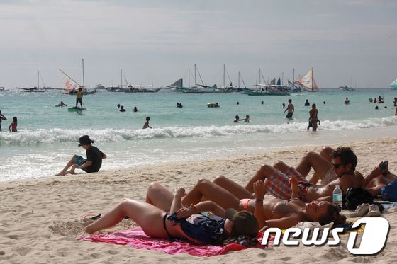필리핀 보라카이 해변에서 일광욕을 즐기는 관광객들. © AFP=뉴스1