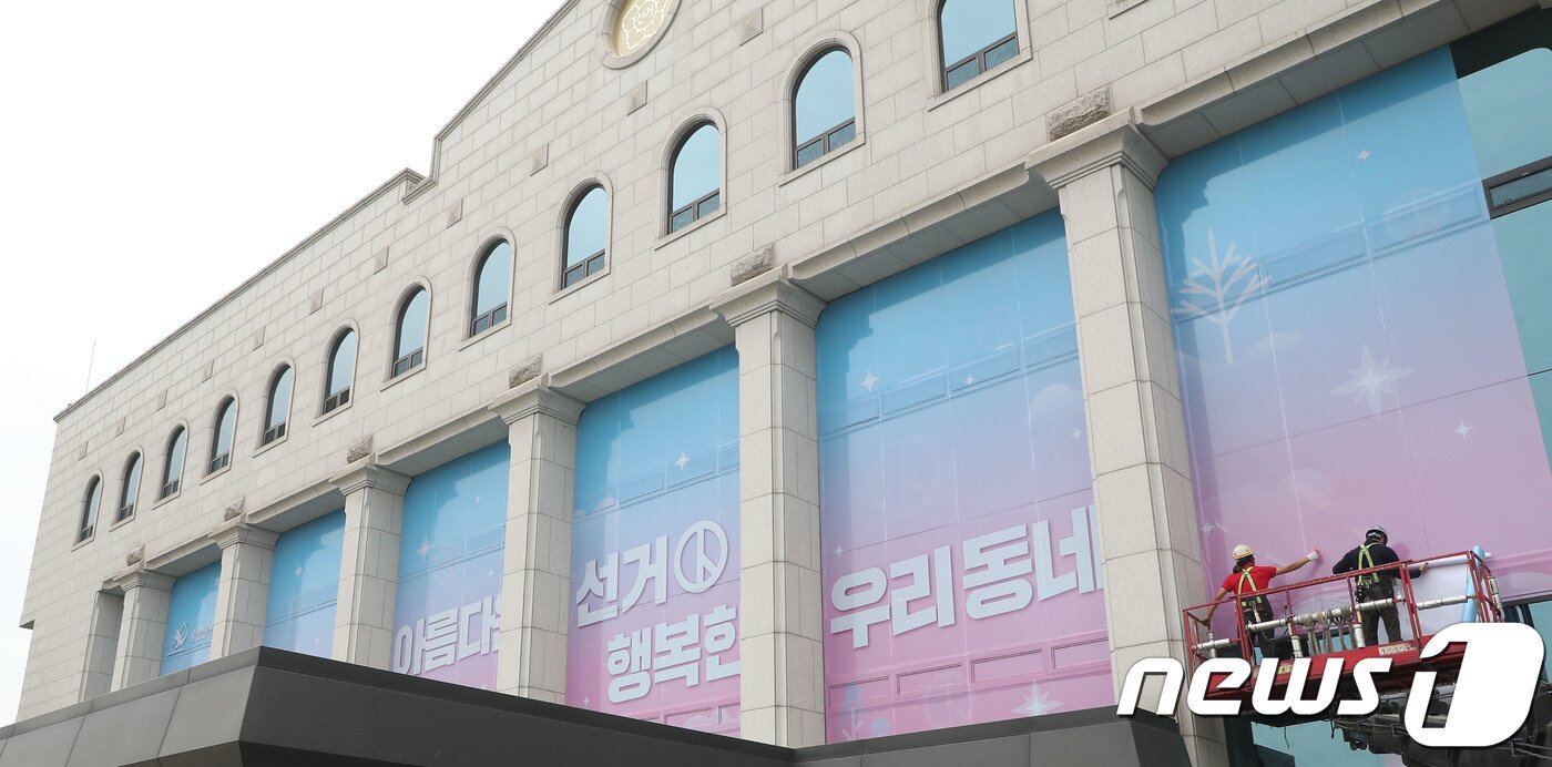 본문 이미지 - 제7회 전국동시지방선선거를 50여일 앞둔 22일 오전 경기 과천시 중앙선거관리위원회 건물 전면 외벽에 작업자들이 지방선거 슬로건 '아름다운 선거, 행복한 우리동네' 래핑 작업을 하고 있다. 2018.4.22/뉴스1 ⓒ News1 오장환 기자