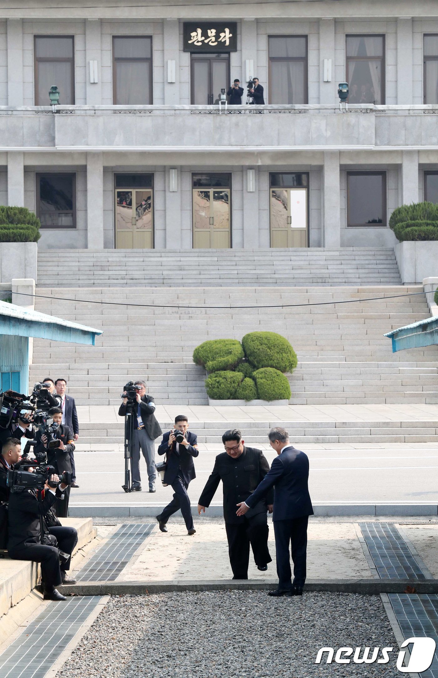 (판문점=뉴스1) 한국공동사진기자단 = 문재인 대통령이 27일 판문점에서 군사분계선을 넘는 김정은 북한 국무위원장을 안내하고 있다.남과 북 양 정상은 이날 세계 유일 분단국가의 상 …