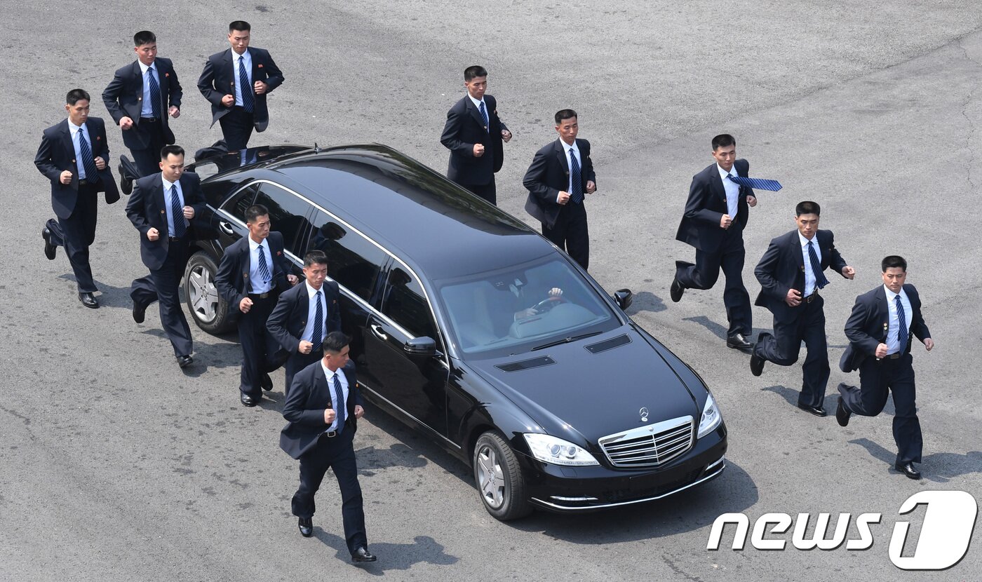 본문 이미지 - 김정은 국무위원장이 27일 판문점 평화의 집에서 문재인 대통령과 오전 정상회담을 마치고 북측으로 가기 위해 차를 타고 이동하고 있다. 12명의 경호원들이 김 위원장의 차량을 에워싼 채 이동하고 있다. 2018.4.27/뉴스1 ⓒ News1 한국공동사진기자단