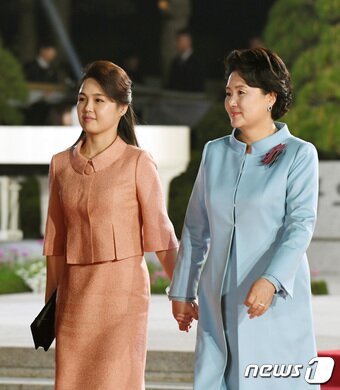 본문 이미지 - 지난 4월27일 김정숙 여사와 리설주 여사가 판문점 남북정상회담 마지막 행사장인 환송공연장으로 손을 잡고 이동하는 모습. 2018.4.27/뉴스1 ⓒ News1 한국공동사진기자단