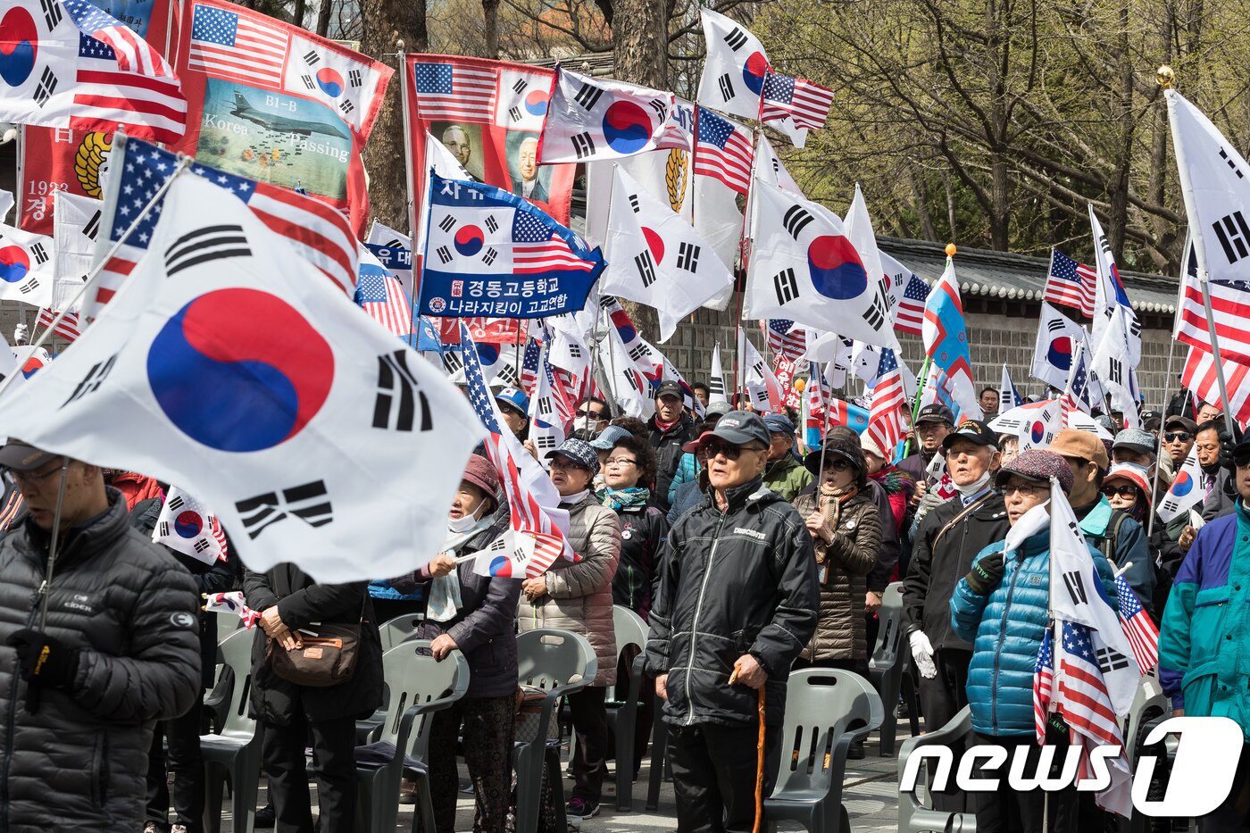 본문 이미지 - 박근혜 전 대통령 지지자들이 7일 서울 덕수궁 대한문 앞에서 열린 태극기시민혁명운동본부 주최 태극기 혁명 국민대회에서 태극기와 성조기를 흔들며 박 전 대통령의 1심 선고 판결에 대해 규탄하고 있다. 6일 법원은 특정범죄가중처벌법상 뇌물수수 혐의 등으로 기소된 박 전 대통령에게 징역 24년과 벌금 180억원을 선고했다. 2018.4.7/뉴스1 ⓒ News1 유승관 기자
