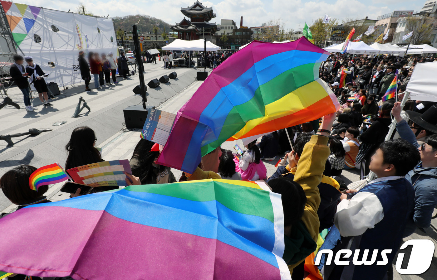 (전주=뉴스1) 문요한 기자 = 7일 전북 전주시 풍남문광장에서 열린 제1회 전주퀴어문화축제에서 참가자들이 무지개 깃발 등을 들고 공연을 관람하고 있다.2018.4.7/뉴스1