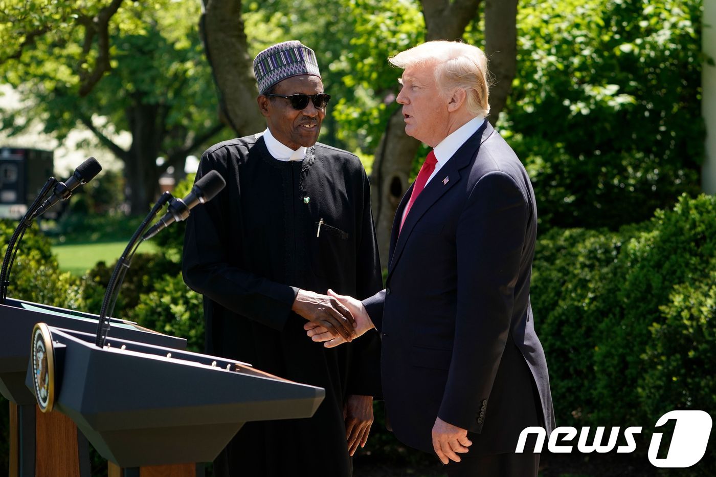(워싱턴 AFP=뉴스1) 우동명 기자 = 도널드 트럼프 미국 대통령이 30일(현지시간) 워싱턴 백악관에서 무함마두 부하리 나이지리아 대통령과 기자회견 중 악수를 하고 있다.ⓒ AF …