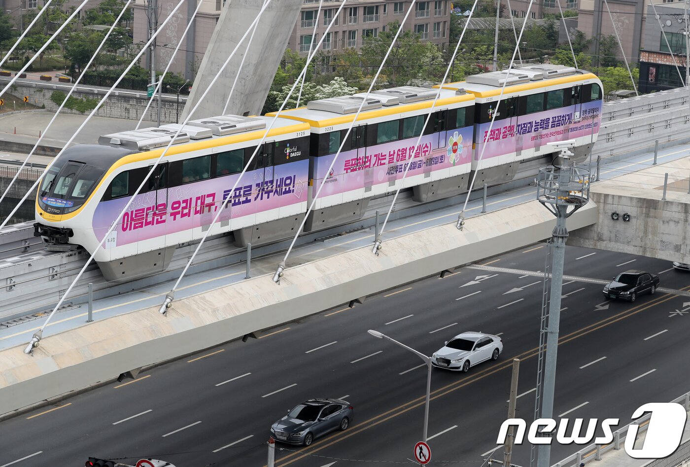 본문 이미지 - '하늘열차'로 불리는 대구도시철도 3호선 모노레일 전동차에 지방선거를 알리는 래핑 광고가 등장했다. 지난 5월1일 유권차 참여와 지방선거를 알리는 문구가 적인 전동차가 대봉교를 지나가고 있다. 2018.5.1/뉴스1 ⓒ News1 공정식 기자
