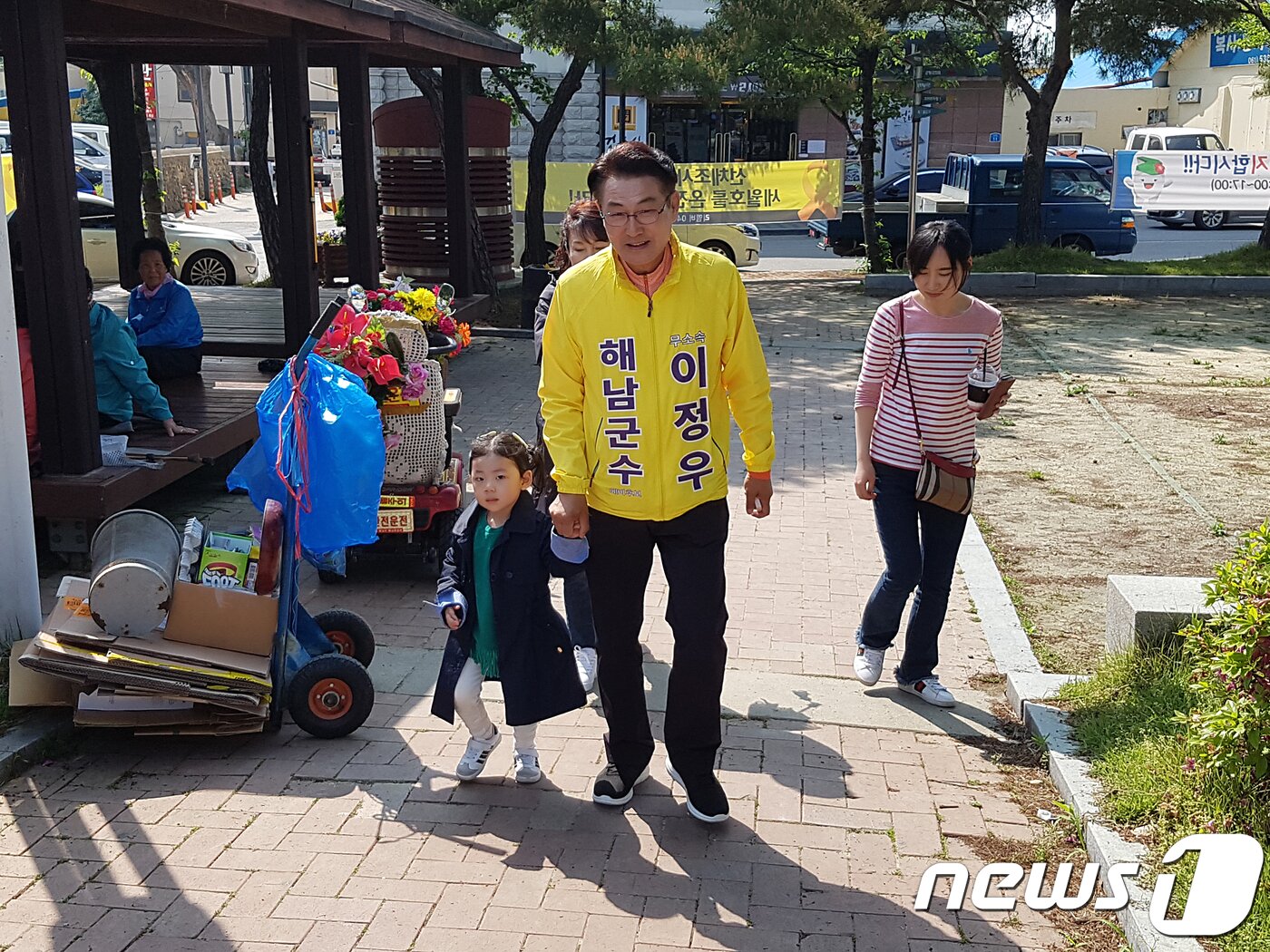 본문 이미지 - 무소속 이정우 해남군수 예비후보가 해남읍에서 아이와 손을 잡고 주민들에게 인사하고 있다.(이정우 선거사무소 제공) ⓒ News1