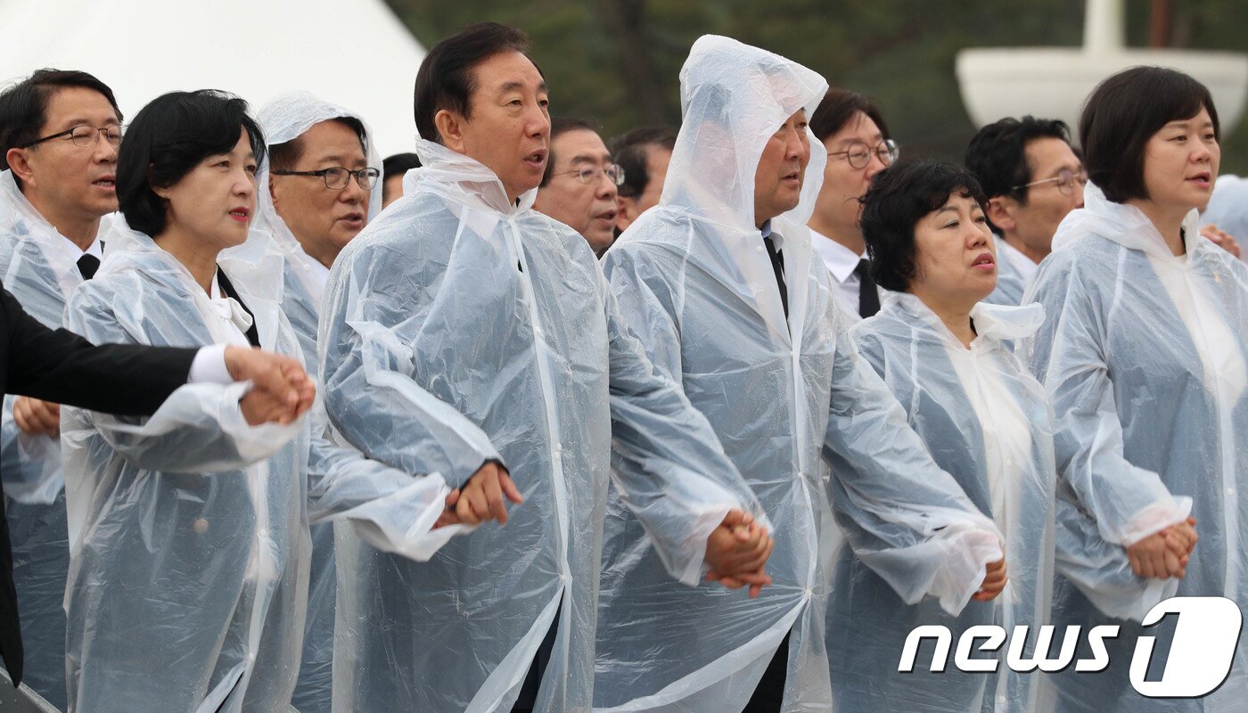 본문 이미지 - 5·18 민주화운동 38주년 기념식이 열린 지난 5월 18일 광주 북구 운정동 국립 5·18민주묘지에서 추미애 더불어민주당 전 대표&#40;왼쪽부터 첫번째&#41;와 김성태 자유한국당 원내대표&#40;왼쪽부터 두번째&#41;가 손을 잡고  &#39;임을 위한 행진곡&#39;을 함께 부르고 있다. 2018.5.18/뉴스1 ⓒ News1 민경석 기자