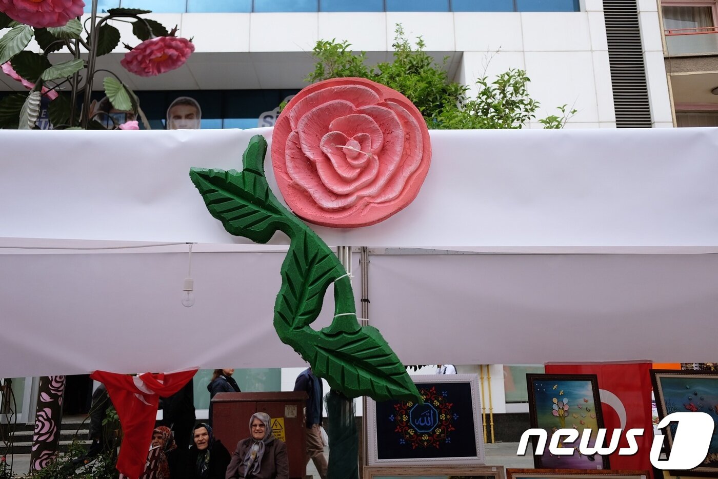 본문 이미지 - 도로 옆에 설치된 천막 위엔 분홍색 장미꽃 장식이 설치돼 있다.ⓒ News1