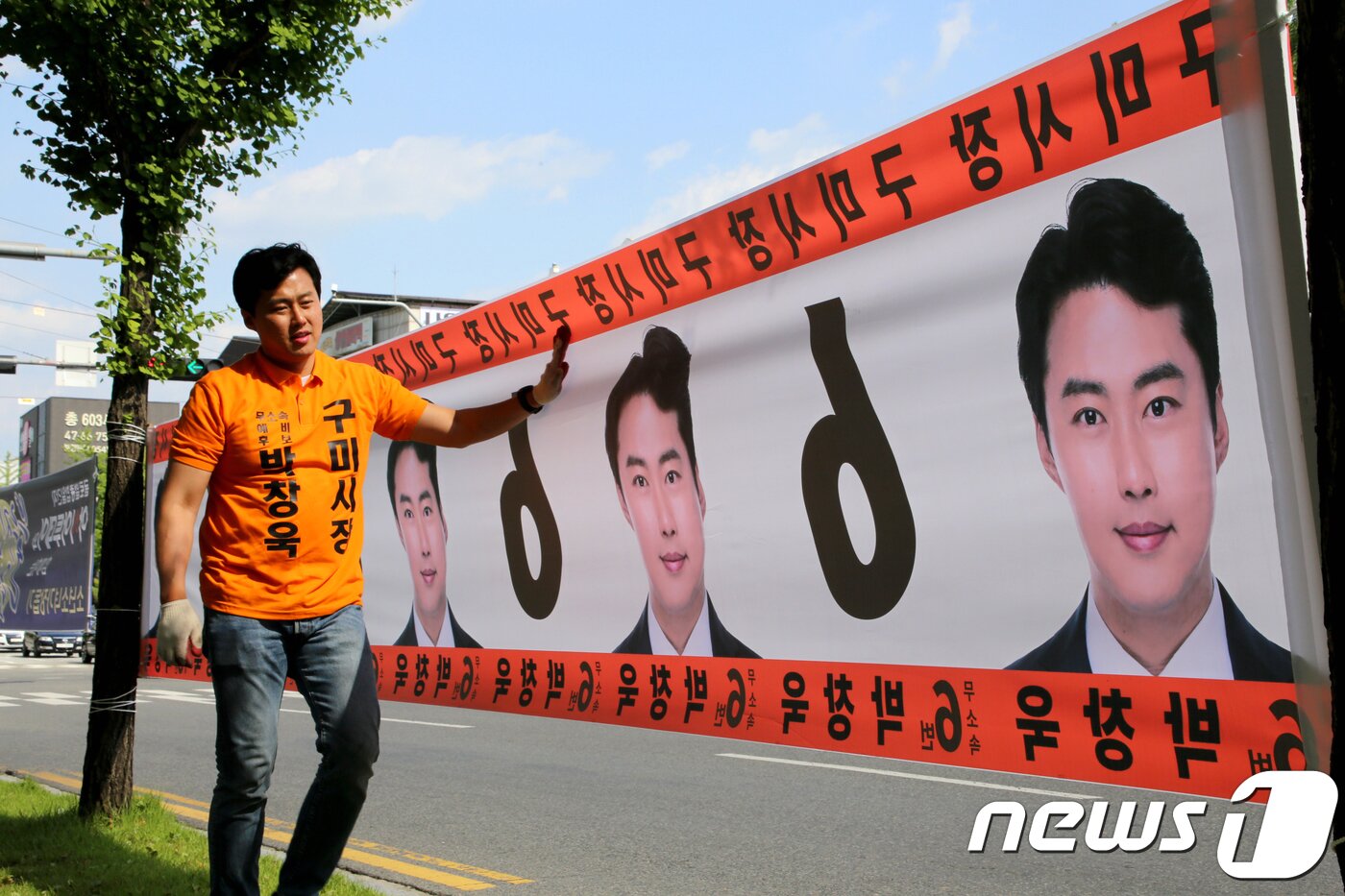 본문 이미지 - 6·13지방선거 공식 선거운동 첫날인 31일 경북 구미시 버스터미널 인근에서 무소속 박창욱 구미시장 후보가 혼자사 선거 홍보용 플래카드를 붙이고 있다. 박후보는 "선거사무원 없이 혼자사 선거를 치른다＂ 며 ＂ 혼자가야 당선돼도 누구 눈치 안보고 구미를 바꿀수 있기 때문＂이라고 말했다.2018.5.31/뉴스1 ⓒ News1 정우용 기자