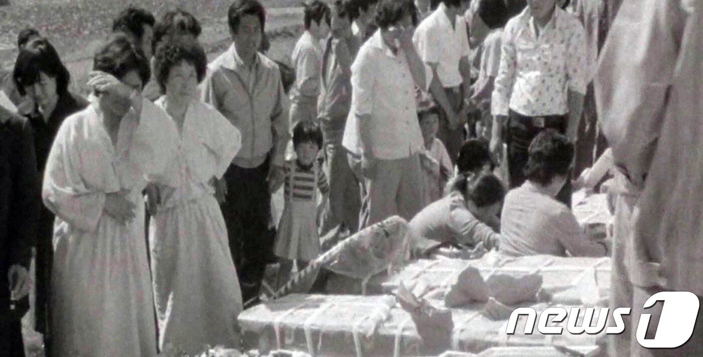 본문 이미지 - 5‧18민주화운동기록관은 9일 오후 국립아시아문화전당에서 5‧18 3단체장과 회원 등이 참석한 가운데 ‘5‧18민주화운동 미공개 영상기록물 상영회’를 개최했다. 기록관이 익명의 수집가로부터 입수한 영상은 1980년 5월 20일부터 6월 1일까지 국군통합병원과 적십자병원 환자 치료 상황, 전남도청 기자회견 등 광주 일대와 근교를 촬영했다. 처음으로 공개되는 이 영상은 이달 10일부터 30일까지 기록관 3층에서 상영된다. 사진은 1980년 5월 유가족들이 오열하는 모습. (5‧18민주화운동기록관 제공영상 갈무리)2018.5.9/뉴스1 ⓒ News1 남성진 기자