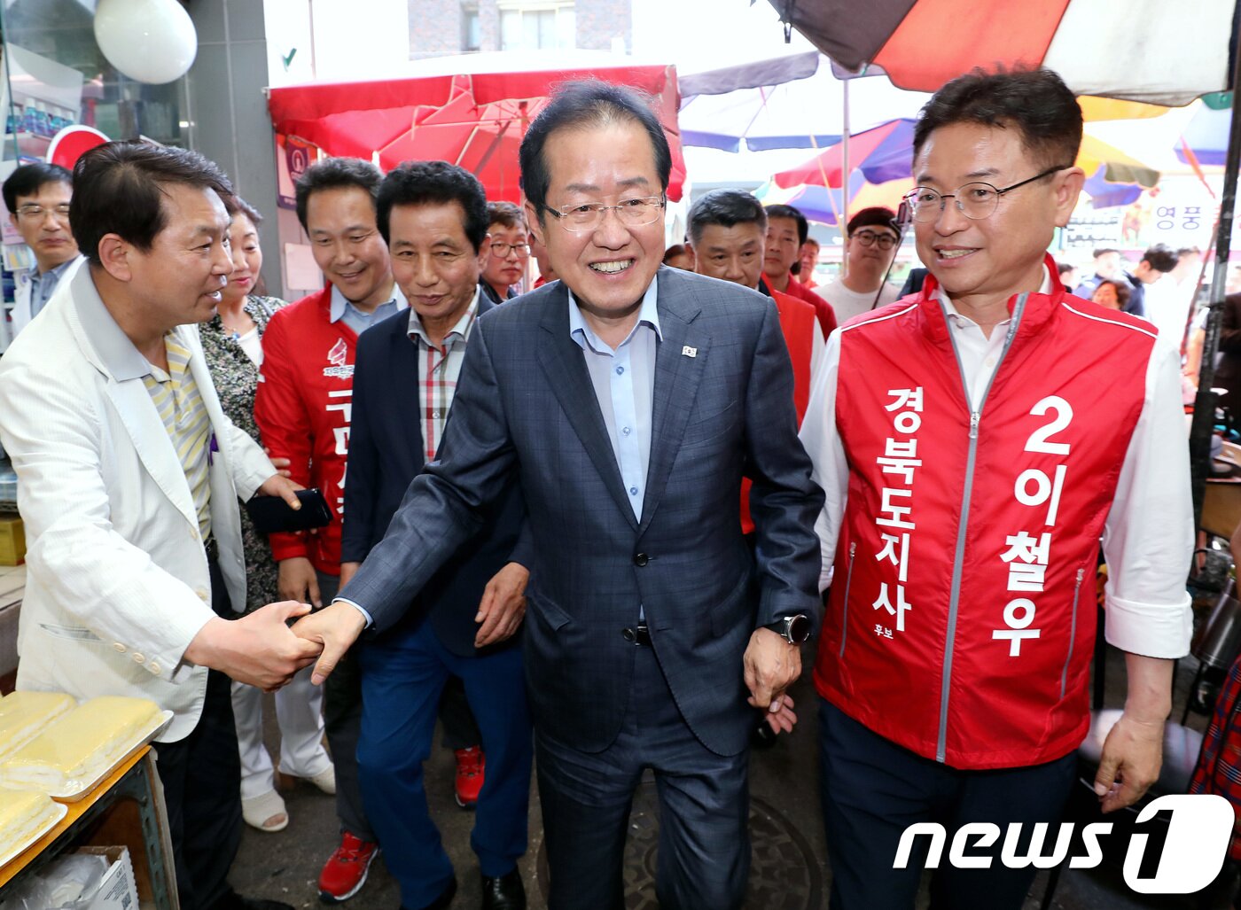 본문 이미지 - 홍준표 자유한국당 대표(중앙선대위 공동위원장)가 1일 오후 경북 구미시 새마을 중앙시장에서 이철우 경북도지사 후보, 이양호 구미시장 후보와 함께 상인 및 시민들과 인사를 나누고 있다. 2018.6.1/뉴스1 ⓒ News1 박정호 기자