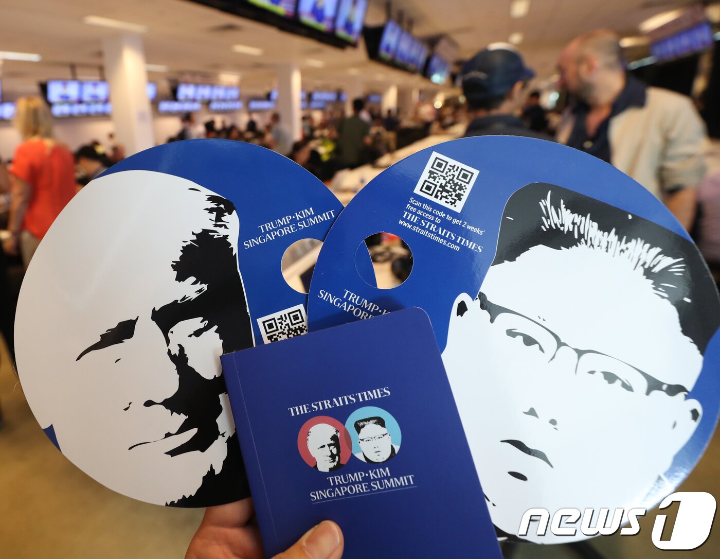 본문 이미지 - 북미정상회담을 이틀 앞둔 10일 프레스센터가 마련된 싱가포르 F1(포뮬러원) 경기장에서 취재진들에게 양국 정상의 사진이 담긴 부채와 수첩이 제공되고 있다. 2018.6.10/뉴스1 ⓒ News1 허경 기자