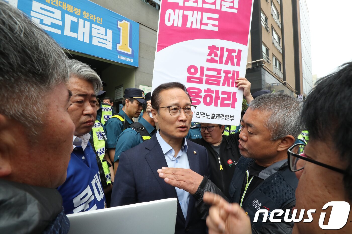 본문 이미지 - 홍영표 더불어민주당 원내대표가 10일 제주시 문대림 제주지사 후보 선거사무소 앞에서 민주노총 제주본부 관계자들과 대화하고 있다. 이날 문 후보 선거사무소 앞에서는 최저임금 산입범위 확대법 폐기를 요구하는 민주노총의 항의 시위가 벌어졌다.2018.6.10/뉴스1 ⓒ News1 이석형 기자
