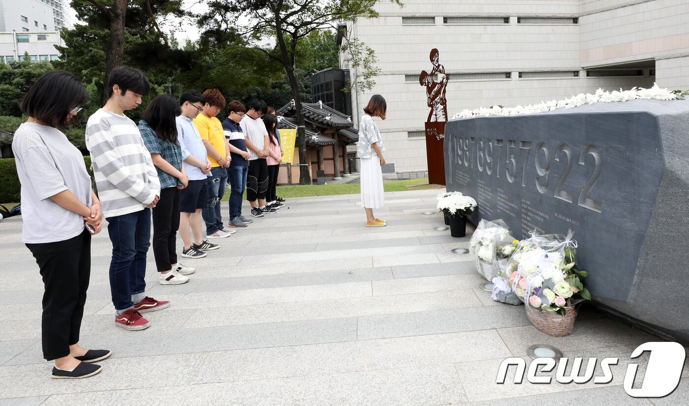 본문 이미지 - 10일 오후 서울 서대문구 연세대학교 한열동산에서 학생들이 고(故) 이한열 열사 추모비에 헌화 후 묵상을 하고 있다. 이한열 열사는 연세대 재학 당시인 1987년 전경이 쏜 최루탄에 맞아 사망했다. 이 열사의 죽음은 6월 항쟁의 도화선이 됐다. 2018.6.10/뉴스1 ⓒ News1 박지수 기자