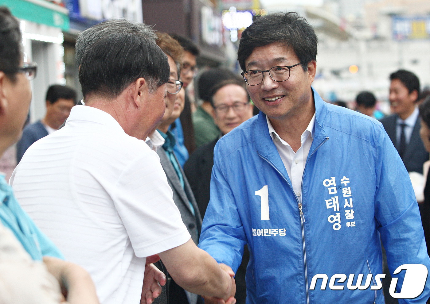 (수원=뉴스1) 오장환 기자 = 염태영 더불어민주당 수원시장 후보가 10일 오후 경기도 수원시 팔달구 지동시장 앞에서 시민들과 인사를 하고 있다. (염태영 후보 캠프 제공) 201 …