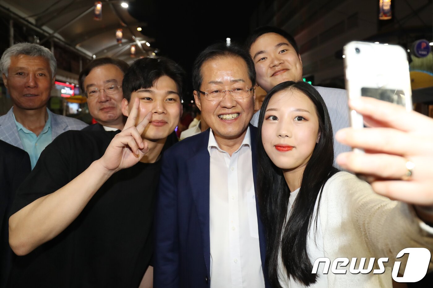 본문 이미지 - 홍준표 자유한국당 대표(앞줄 오른쪽 두번째)가 6·13 지방선거를 이틀 앞둔 11일 오후 대구 서문시장을 전격 방문해 야시장을 찾은 시민들과 기념사진을 찍고 있다. 2018.6.11/뉴스1 ⓒ News1 공정식 기자