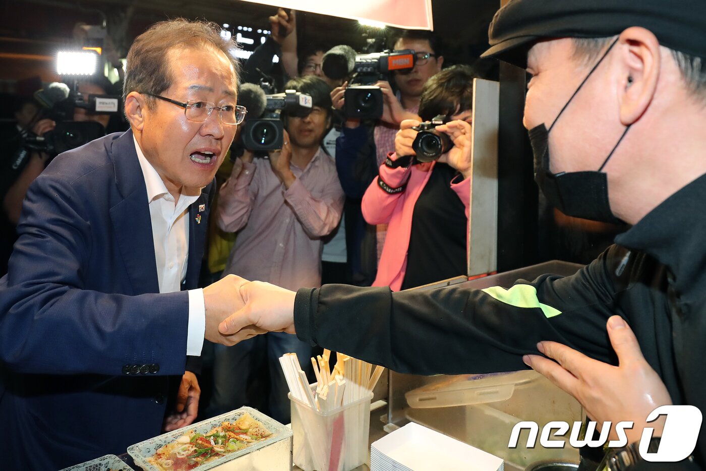 본문 이미지 - 홍준표 자유한국당 대표(왼쪽)가 6·13 지방선거를 이틀 앞둔 11일 오후 대구 서문시장을 전격 방문해 야시장 상인과 악수하고 있다. 2018.6.11/뉴스1 ⓒ News1 공정식 기자