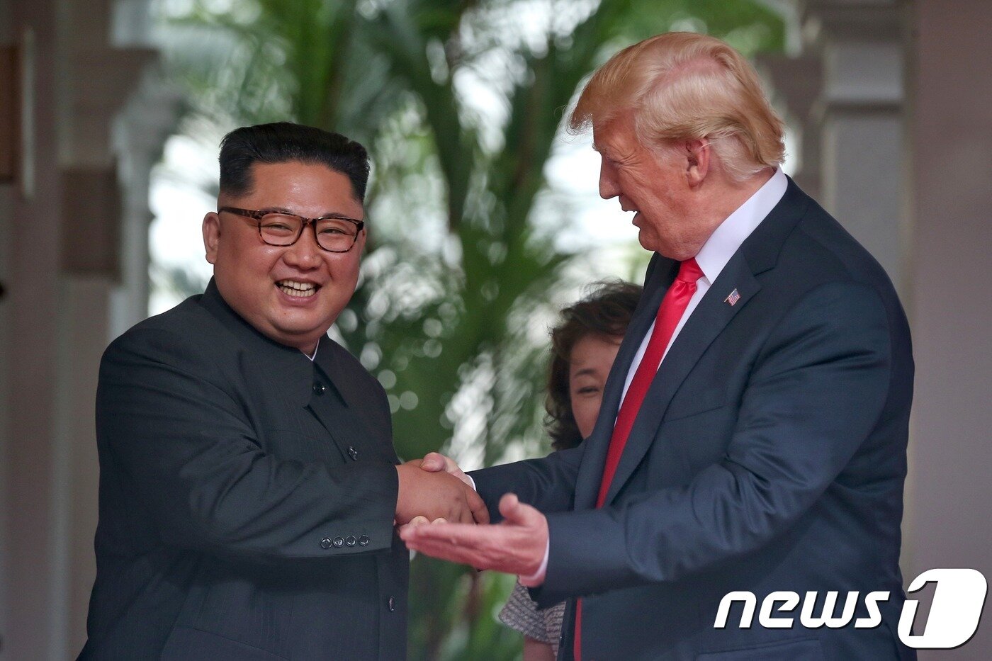 본문 이미지 - 도널드 트럼프 미국 대통령과 김정은 북한 국무위원장이 12일 오전 북미 정상회담이 열린 싱가포르 센토사섬 카펠라호텔에서 악수를 나누고 있다. (싱가포르통신정보부 제공) 2018.6.12/뉴스1