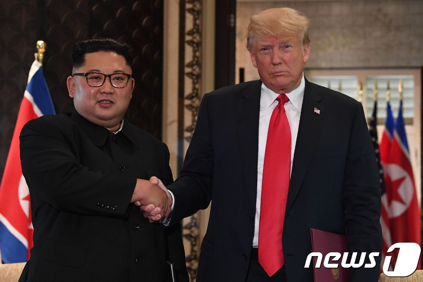본문 이미지 - 김정은 북한 국무위원장과 도널드 트럼프 미국 대통령이 12일(현지시간) 싱가포르 센토사 섬 카펠라 호텔에서 140여 분에 걸친 단독·확대정상회담과 업무오찬을 마친 뒤 북미정상회담 공동합의문에 서명 후 악수를 하고 있다. 2018.06.12ⓒ AFP=뉴스1 ⓒ News1 우동명 기자