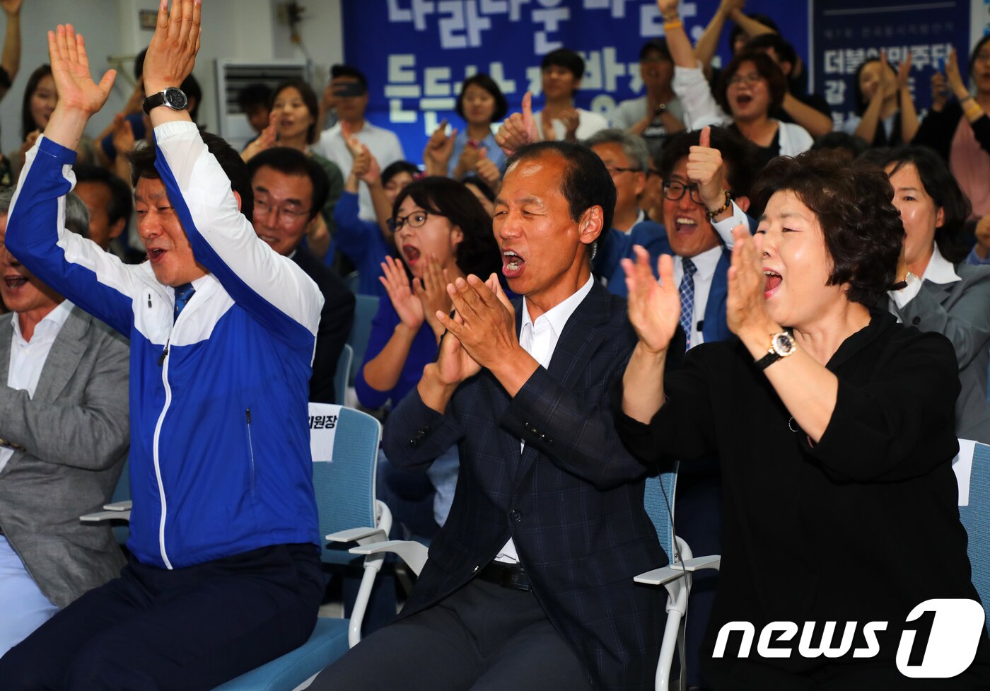 본문 이미지 - 최문순 더불어민주당 강원도지사 후보와 부인 이순우 여사, 심기준 더불어민주당 강원도당위원장(왼쪽)이 13일 오후 6시 강원 춘천시 더불어민주당 강원도당에서 6·13 지방선거 출구조사 결과를 보고 환호하고 있다. 2018.6.13/뉴스1 ⓒ News1 하중천 기자