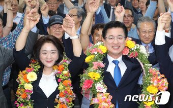 본문 이미지 - 허태정 더불어민주당 대전시장 후보가 13일 오후 대전 서구 선거사무실에서 6·13지방선거에서 당선이 확실시 되자 부인 양창희씨와 함께 꽃목걸이를 목에 걸고 기뻐하고 있다. 2018.6.13/뉴스1 ⓒ News1 주기철 기자