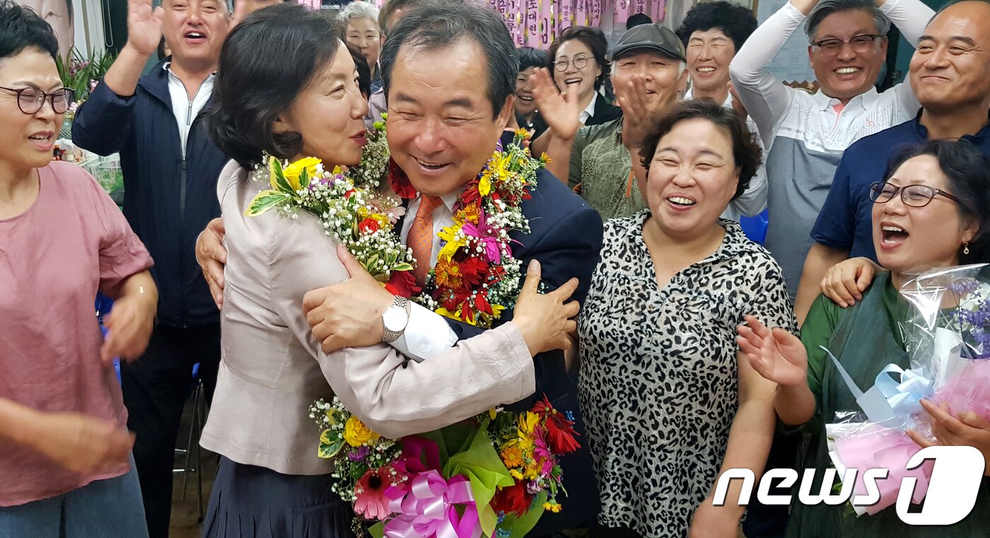 본문 이미지 - 14일 오전 자유한국당을 김응규 후보를 따돌리고 경북 김천시장에 당선된 무소속 김충섭(63) 후보가 선거사무실에서 지지자들이 걸어 준 축하 화환을 목에 걸고 부인 김경자씨와 함께 기뻐하고 있다.2018.6.14/뉴스 ⓒ News1 정우용 기자