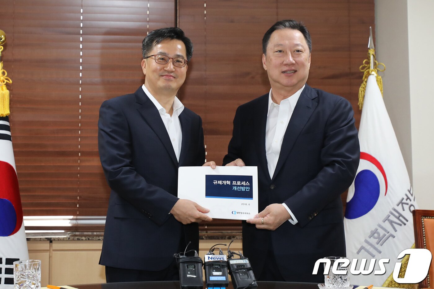본문 이미지 - 박용만 대한상공회의소 회장(오른쪽)이 15일 오전 서울 세종로 정부서울청사에서 김동연 경제부총리 겸 기획재정부 장관에게 규제개혁관련 정책건의서를 전달하고 있다. 2018.6.15/뉴스1 ⓒ News1 임세영 기자