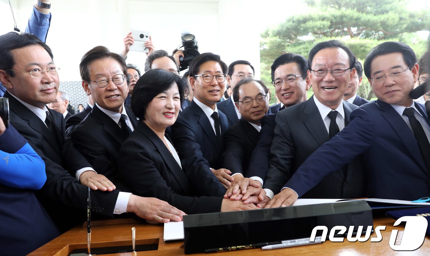 본문 이미지 - 추미애 더불어민주당 대표와 홍영표 원내대표를 비롯한 광역단체장 당선인들이 15일 오전 동작동 국립서울현충원 현충탑 참배를 마친 뒤 당선인 대표 방명록에 손을 모으로 있다. 2018.6.15/뉴스1 ⓒ News1 박정호 기자