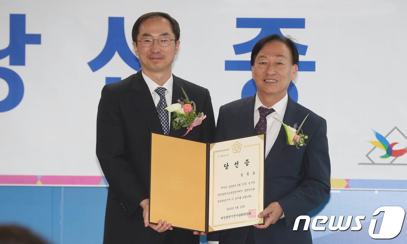 본문 이미지 - 6.13지방선거에서 당선된 설동호 대전시교육감 당선인(오른쪽)이 15일 오전 대전 선거관리위원회에서 열린 당선증 교부식에 참석해 김필곤 대전시선관위 위원장으로부터 당선증을 전달받은 뒤 기념사진을 찍고 있다. 2018.6.15./뉴스1 ⓒ News1 주기철 기자
