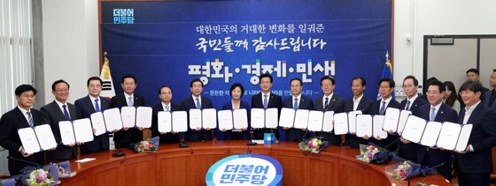 본문 이미지 - 추미애 더불어민주당 대표와 홍영표 원내대표를 비롯한 시도지사 등이 15일 오전 서울 여의도 국회 당대표실에서 열린 '나라다운 나라, 든든한 지방정부 실현을 위한 국민과의 약속 선포식'에서 손을 맞잡아 들어 인사하고 있다.  2018.6.15/뉴스1 ⓒ News1 박정호 기자