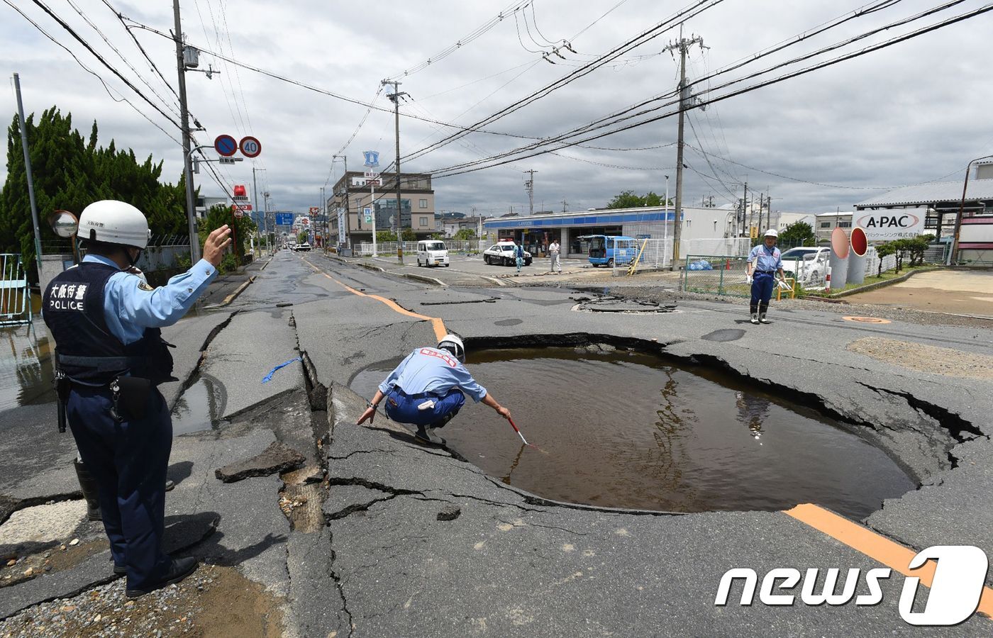 본문 이미지 - 일본 오사카부 타카쓰키시에서 18일 발생한 지진으로 도로가 함몰됐다. ⓒ AFP=뉴스1