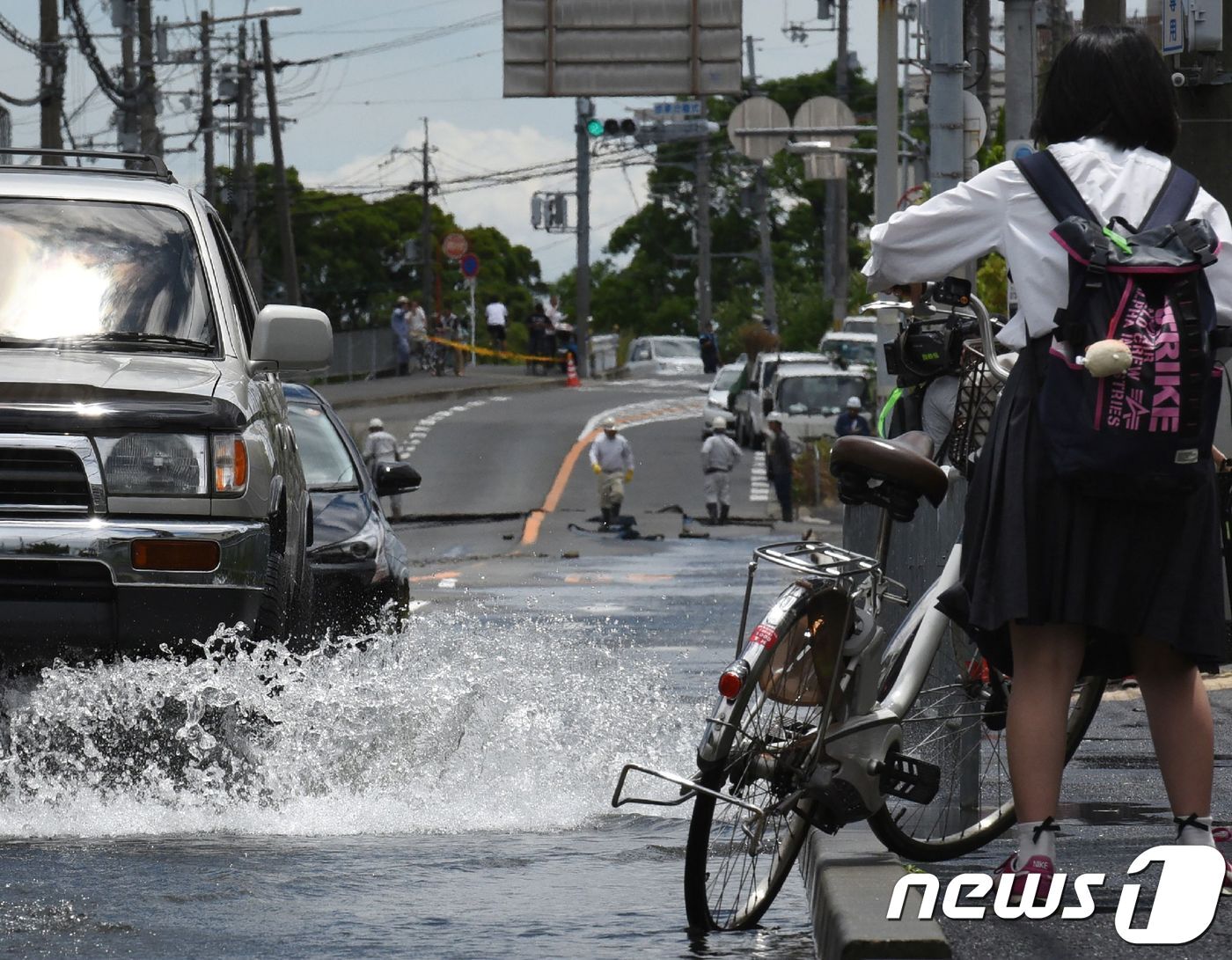 본문 이미지 - 18일(현지시간) 일본 오사카 부근에서 진도 5.9의 지진 발생해 다카쓰키의 도로에 물이 넘쳐흐르는 모습이 보인다. ⓒ AFP=뉴스1 ⓒ News1 우동명 기자