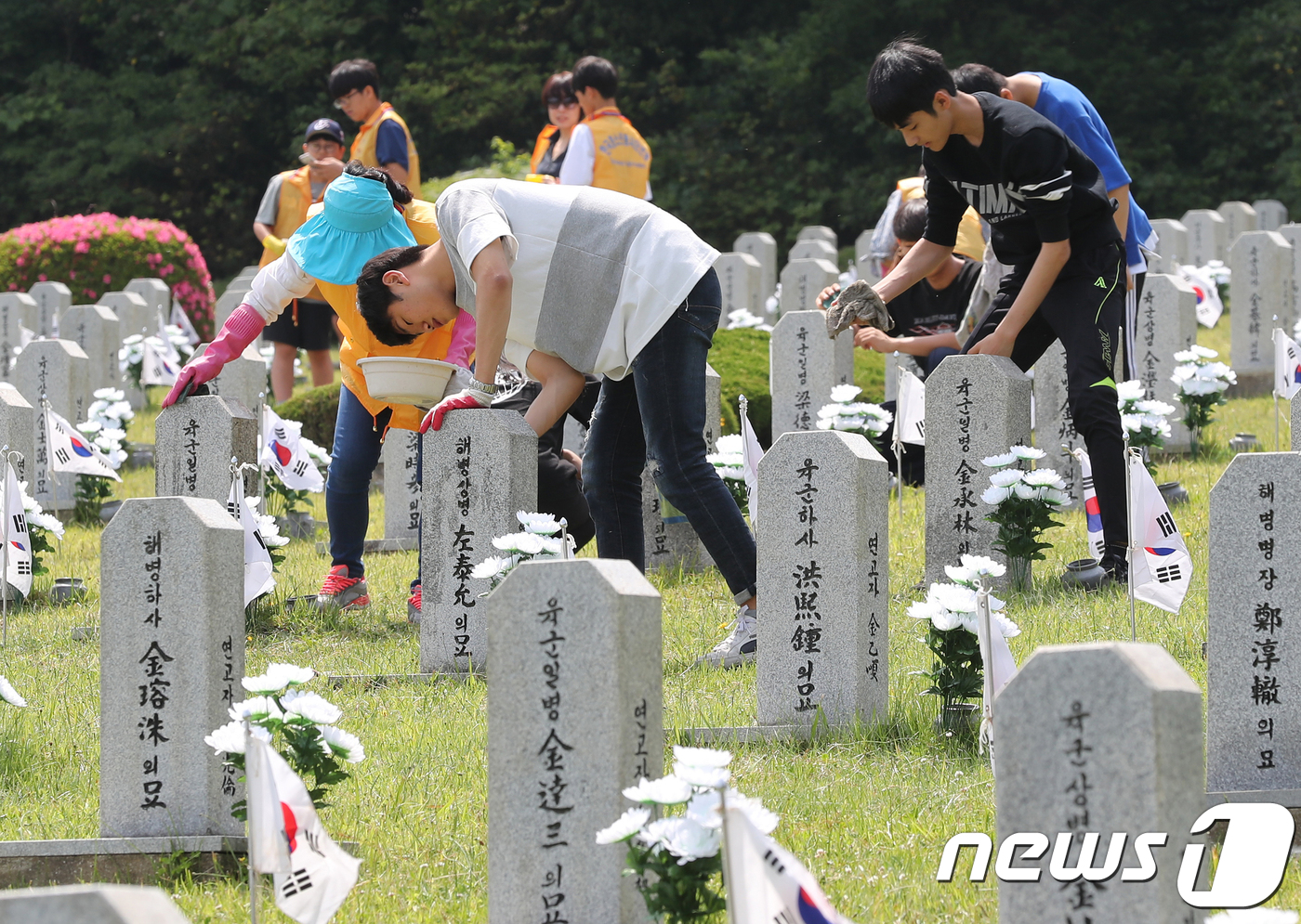 (제주=뉴스1) 이석형 기자 = 제63회 현충일을 사흘 앞둔 3일 제주시 노형동 제주시 충혼묘지에서 청소년봉사단체와 학부모들이 묘비를 닦고 있다.2018.6.3/뉴스1