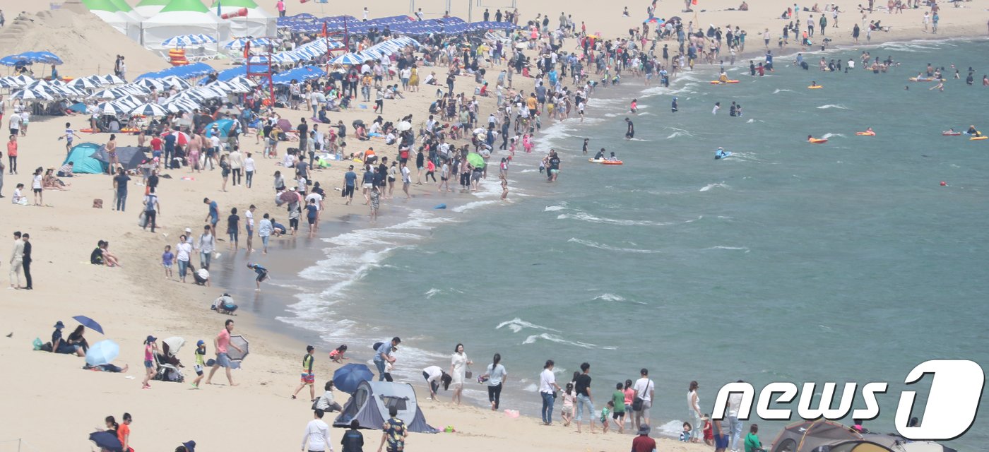 부산 해운대 해수욕장 개장 후 첫 주말을 맞은 3일 관광객들이 해변에서 물놀이를 즐기고 있다. 부산지역 해운대·송정·송도 해수욕장은 지난 1일 개장을 했다. 2018.6.3/뉴스1 ⓒ News1  