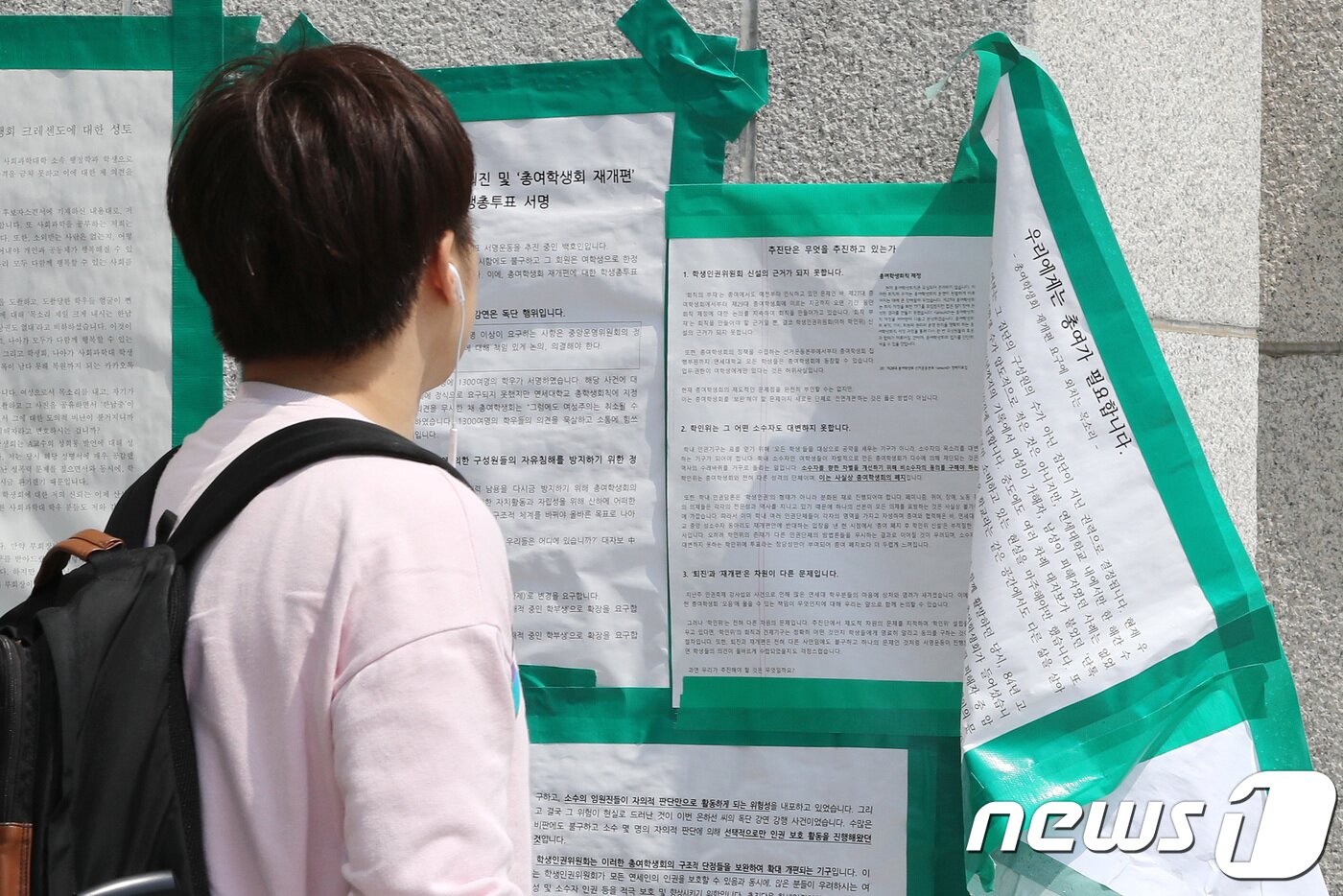 본문 이미지 - 한 학생이 4일 오전 서울 서대문구 연세대학교 중앙도서관 앞에서 떨어진 총여학생회(총여) 대자보를 바라보고 있다. 연세대 총여학생회측은 총여 재개편 격론이 심화되면서 이틀째 총여의 대자보가 훼손되고 있다고 밝혔다.  2018.6.4/뉴스1 ⓒ News1 박지수 기자