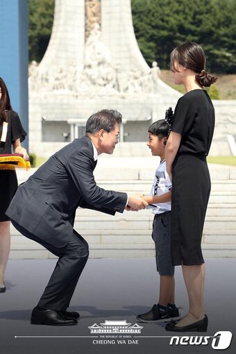 본문 이미지 - 문재인 대통령이 6일 국립대전현충원에서 열린 제63회 현충일 추념식에서 국가유공자증서 대리 수상자인 고(故) 정연호 경위 아들 정준용 군을 격려하고 있다.(청와대 페이스북) 2018.6.6/뉴스1