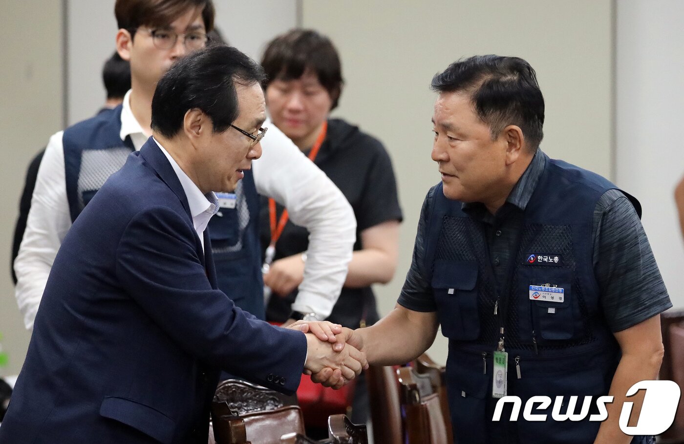 본문 이미지 - 류장수 최저임금위원회 위원장&#40;왼쪽&#41;과 이성경 근로자위원이 14일 정부세종청사 고용노동부 내 최저임금위 전원회의장에서 열린 15차 전원회의를 마친 뒤 악수를 나누고 있다. 근로자위원안 8680원과 공익위원안 8350원을 투표한 결과 8표를 얻은 공익위원안 8350원이 최종 확정됐다. 2018.7.14/뉴스1 ⓒ News1 장수영 기자