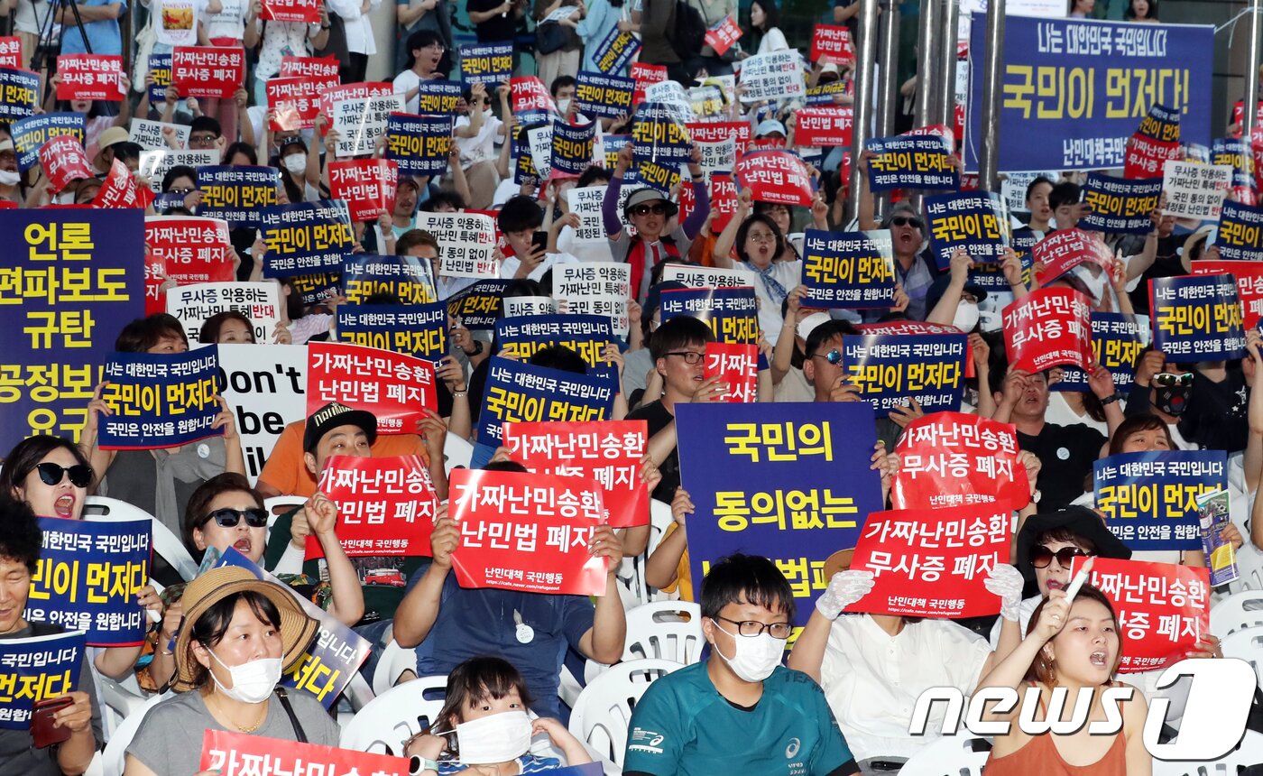 본문 이미지 - 지난 2018년 4월 14일 난민대책국민행동 회원들이 서울 광화문 동화면세점 앞에서 열린 '제주 예멘 난민수용 반대 집회'에서 손팻말을 들고 구호를 외치고 있다.2018.7.14/뉴스1 ⓒ News1 황기선 기자