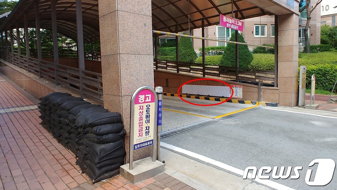 본문 이미지 - 14일 청주 복대동 지웰홈스 아파트 지하 주차장에 침수 예방을 위한 차수막(빨간 원 안)과 모래주머니가 쌓여있다.ⓒ News1