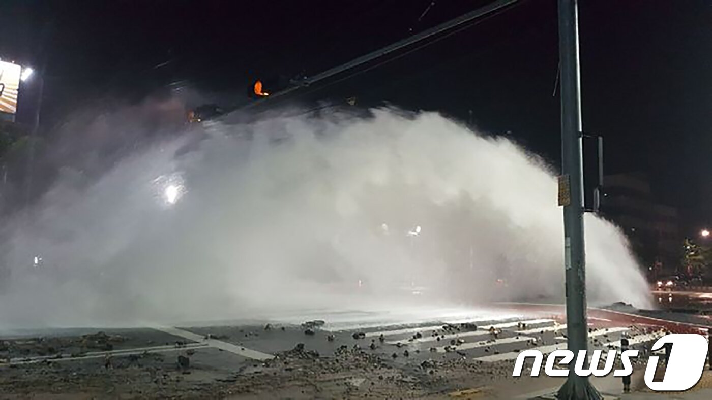 본문 이미지 - 25일 오전 4시1분쯤 대구 서구 평리동 평리네거리 도로에 지하에 매설된 상수도 배관이 파손돼 물기둥이 솟아 올라오고 있다. 이 사고로 약 지름 4m 크기의 싱크홀이 생겼다.(대구소방본부제공)2018.7.26/뉴스1 ⓒ News1 