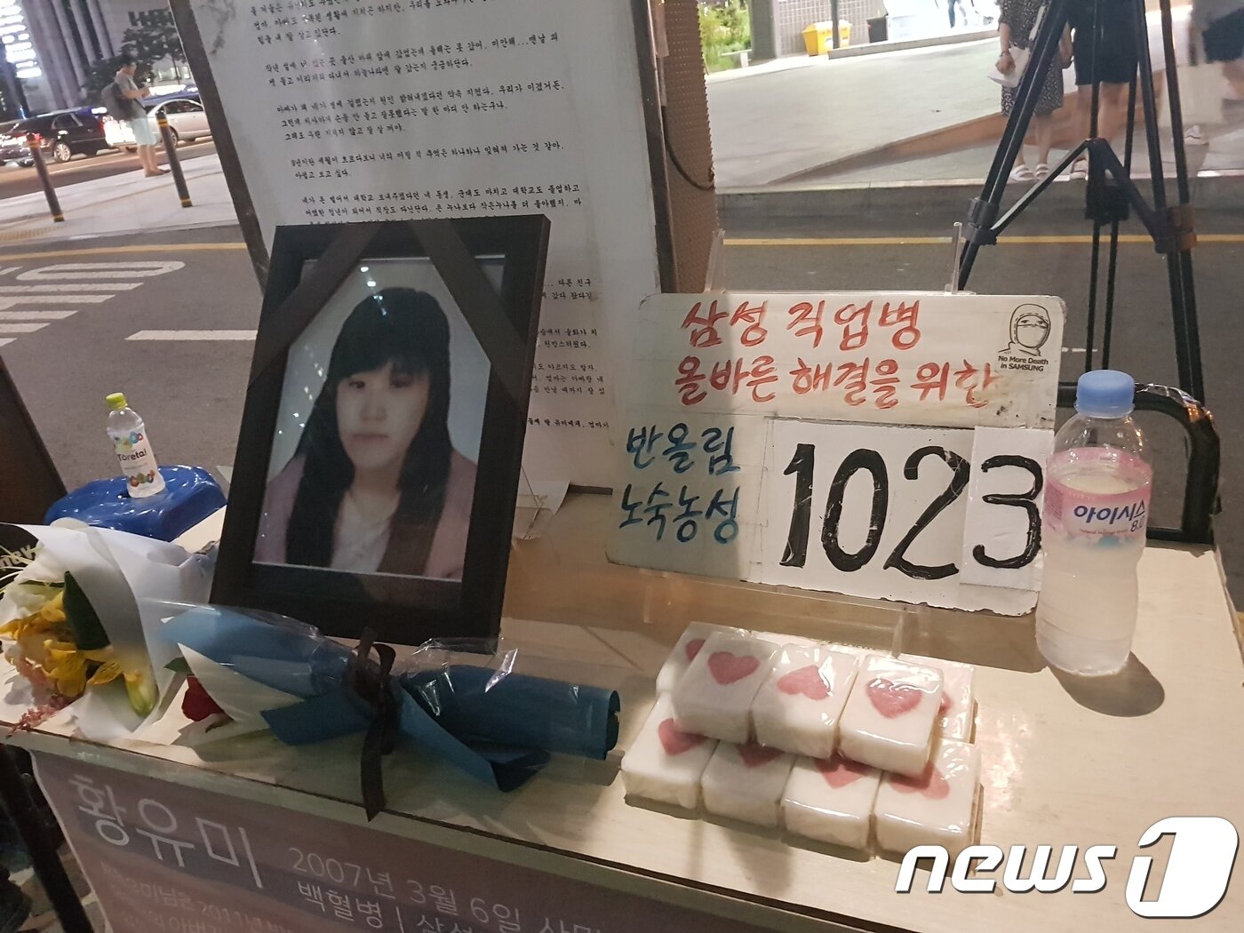 본문 이미지 - 지난해 7월 '11년의 싸움, 1023일의 농성을 기억하는 이들과 함께하는 농성 마침 문화제'가 열린 서울 강남역 8번 출구 앞에 삼성 직업병 피해자 고황유미씨의 영정이 놓여 있다. 2018.7.25/뉴스1 ⓒ News1 윤다정 기자
