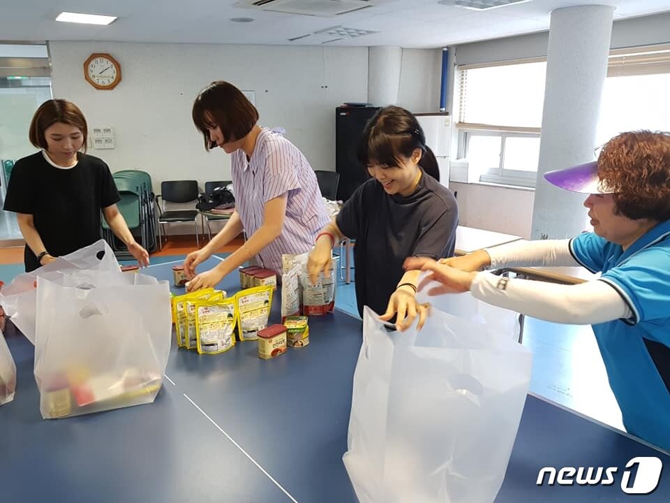 본문 이미지 - 7월25일 구연경씨가 활동하고 있는 서울 용산구 한남동 지역사회보장협의체 회원들이 독거 노인들에게 전달한 후원물품을 정리하고 있다. 구씨는 협의체의 총무를 당담하고 있다. (한남동주민센터 SNS에서 갈무리) ⓒ News1