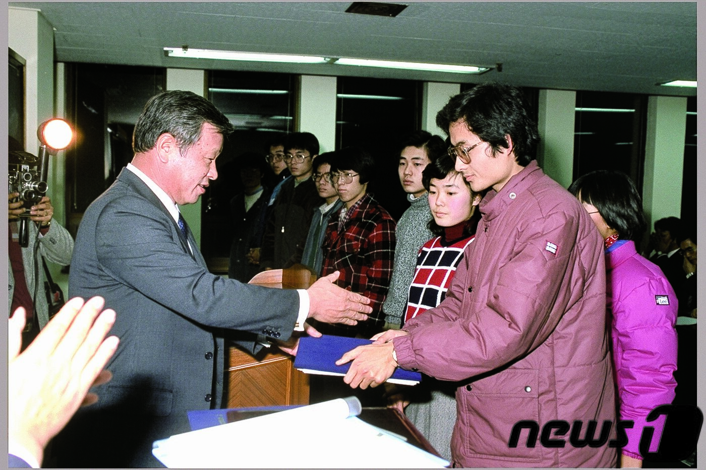본문 이미지 - 故 최종현 회장이 1986년 해외 유학을 앞둔 한국고등교육재단 장학생들에게 장학증서를 전달하고 있다. ⓒ News1