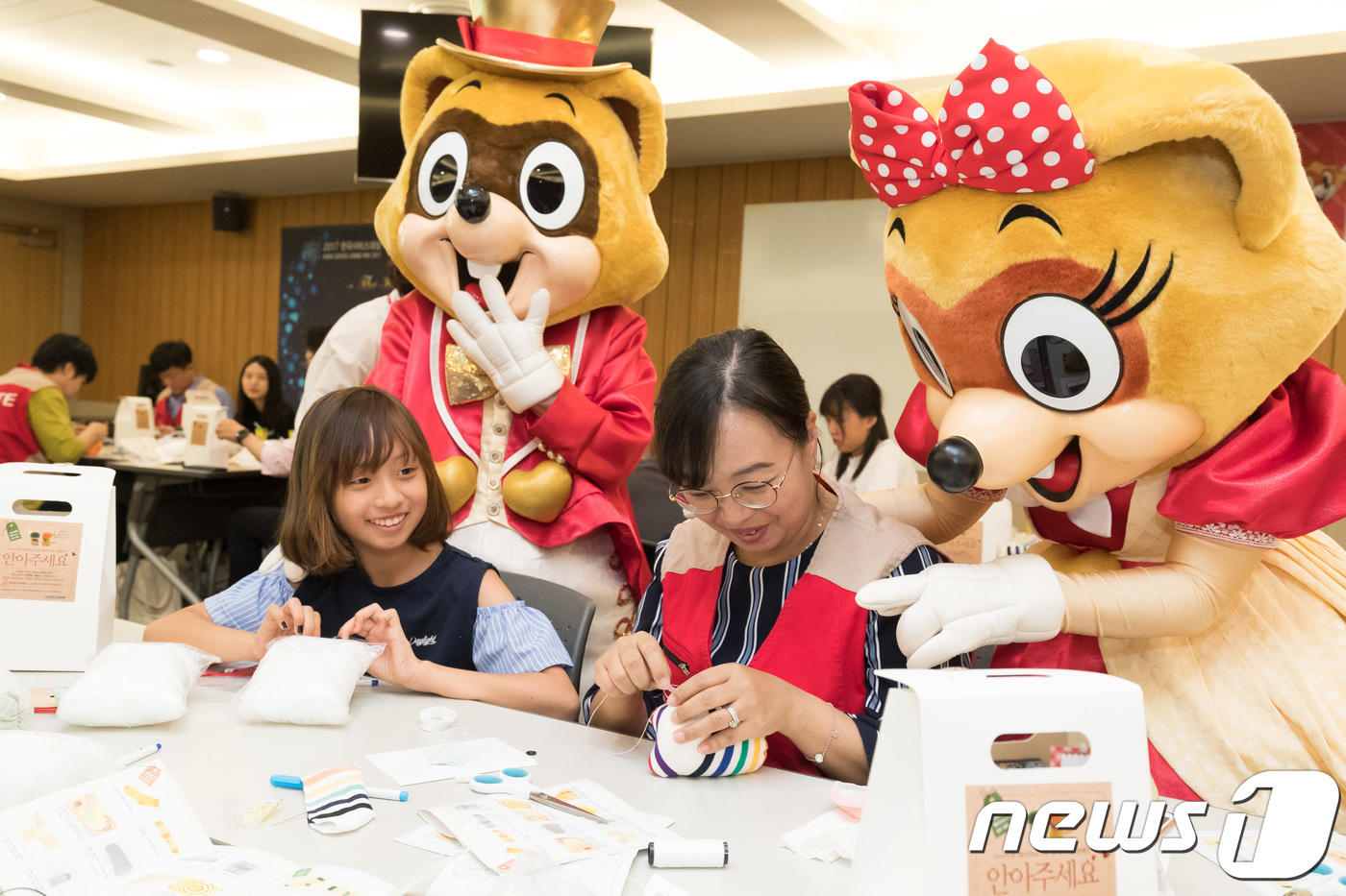 (서울=뉴스1) = 13일 서울 송파구 롯데월드 웰빙센터에서 롯데월드 샤롯데 봉사단이 자녀와 신생아 애착인형을 정성스럽게 만든 후 메시지 카드를 작성하고 있다.롯데월드 임직원들이 …