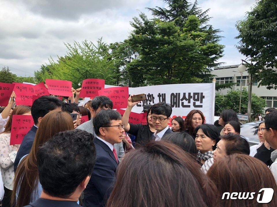 본문 이미지 - 지난 6월 12일 부산대 예술대학 재학생들이 실기수업 시수 조정안에 반발하며 전호환 총장에게 항의하고 있다.(독자제공)ⓒ News1