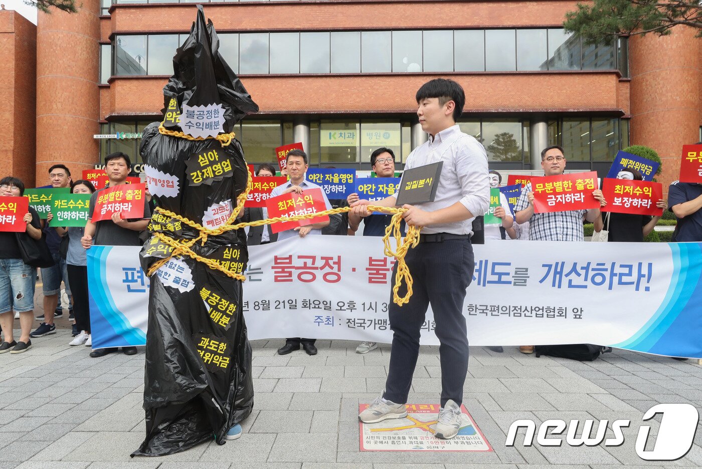 본문 이미지 - 21일 서울 송파구 한국편의점산업협회 앞에서 편의점 전국가맹점주협의회 회원들이 편의점 제도개선을 촉구하는 기자회견을 한 뒤 본사 갑질을 규탄하는 퍼포먼스를 하고 있다. 이번 기자회견에서 전국가맹점주협의회 회원들은 지원금 중단을 이유로 24시간 영업 강제를 중단할 것과 실질적 최저수익 보장으로 무분별한 출점 중단을 각 편의점 본사에 촉구했다. 2018.8.21/뉴스1 ⓒ News1 성동훈 기자