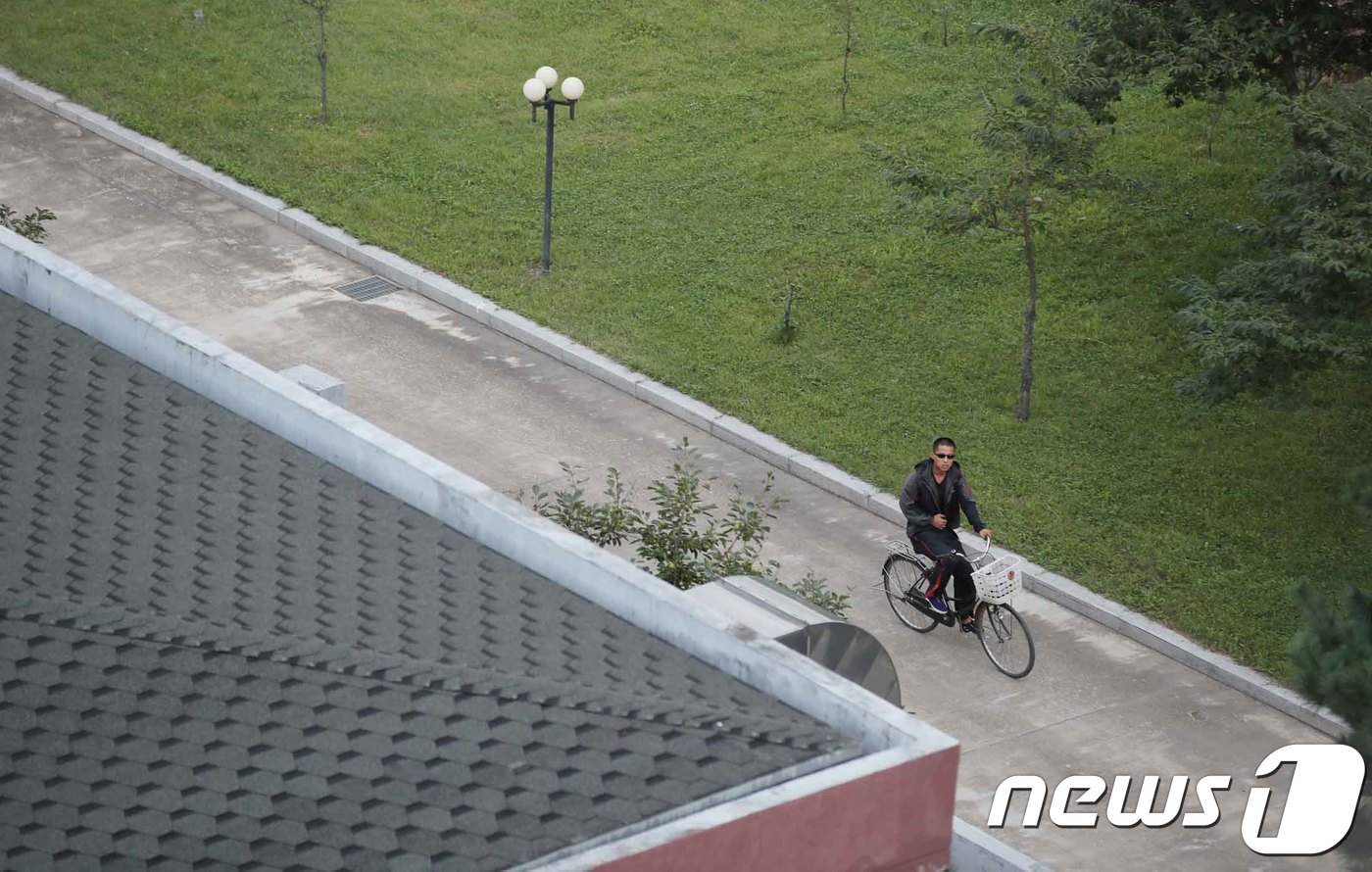 (금강산=뉴스1) 뉴스통신취재단 = 이산가족 상봉행사 1회차 마지막날인 22일 북한 외금강호텔에 북한 주민이 자전거를 타고 이동하고 있다. 2018.8.22/뉴스1